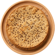 Round Indian snack jeera khakhra topped with cumin seeds on a beige plate.