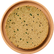 Round crispy Indian snack with herbs on a brown clay plate.